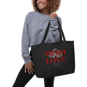 Smiling person holding tote bag reading "MUSH LOVE